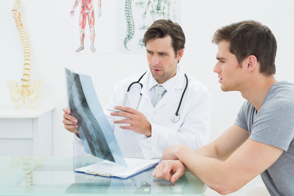A Roselle chiropractor explains his recommended treatment with an x-ray to help illustrate the patient's issues.