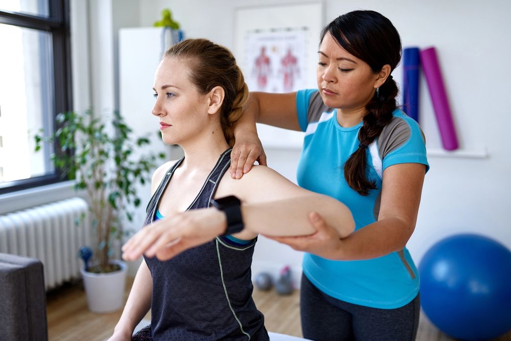 A woman having her arm examined by a personal injury chiropractor.