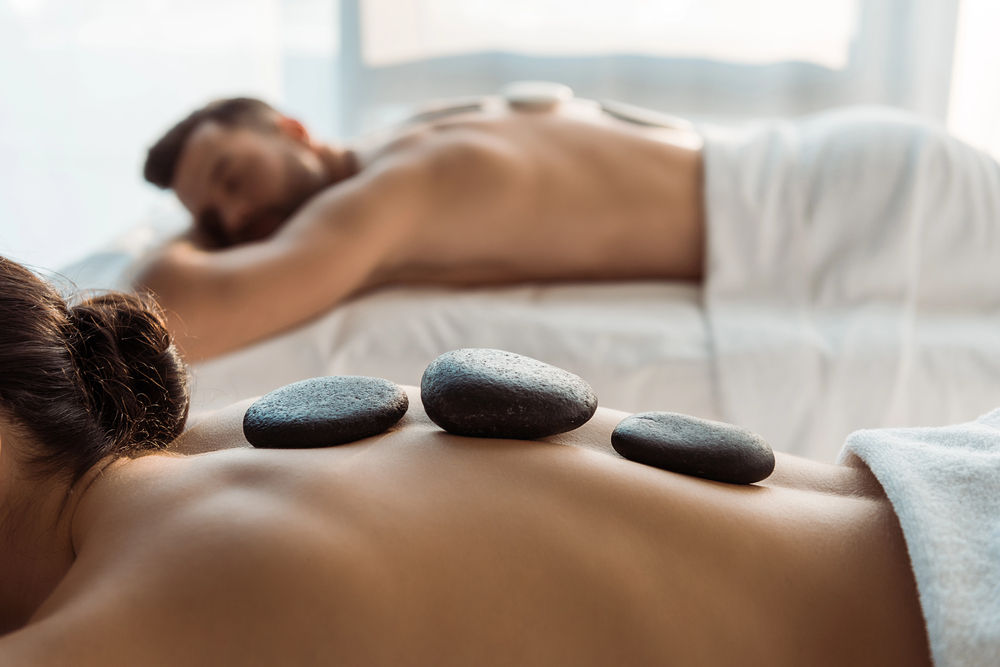 A couple with hot stones on their backs as part of their hot stone massage in Roselle, IL.